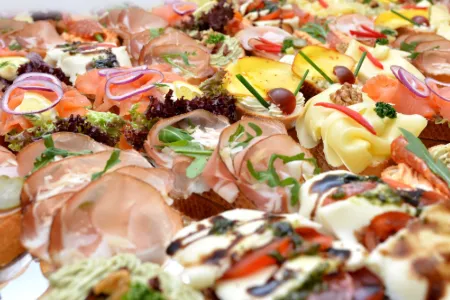 Bunt belegte Brötchenhälften mit Schinken, Lachs, Käse und Mozzarella