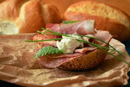 Brötchenhälfte mit Schinken, Salami, Frischkäse und Schnittlauch