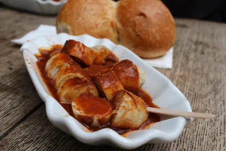 Currywurst mit Currysauce und Brötchen