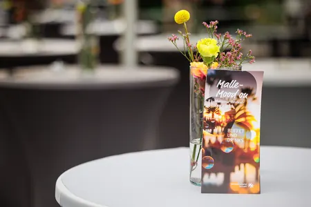 Dekorierter Stehtisch mit Blumen und Getränkekarte